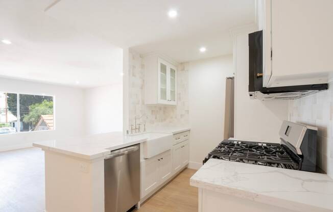 a white kitchen with a stove and a microwave