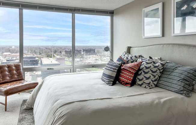 A bedroom with a large bed and a view of the city.