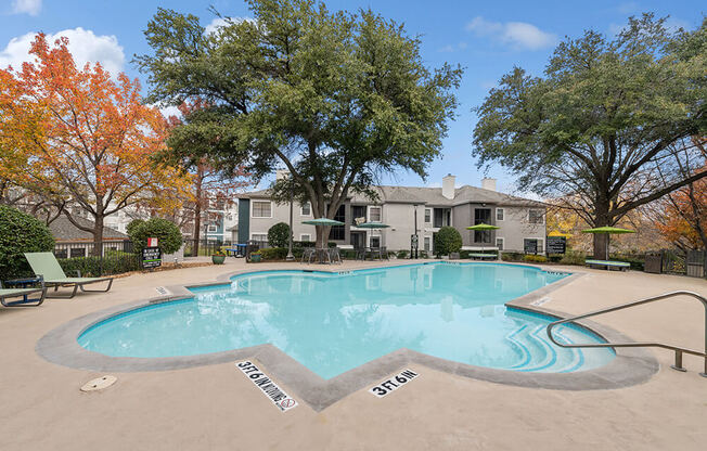 Community Swimming Pool with Pool Furniture at Bridges at Oakbend Apartments in Lewisville, TX.