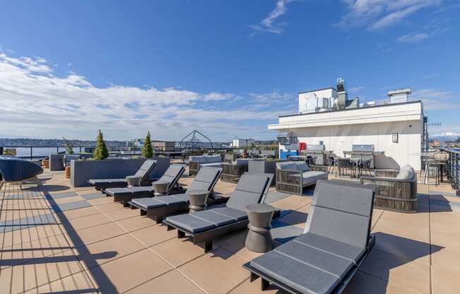 a roof top deck with lounge chairs and a barbecue at Marina Square, WA 98337