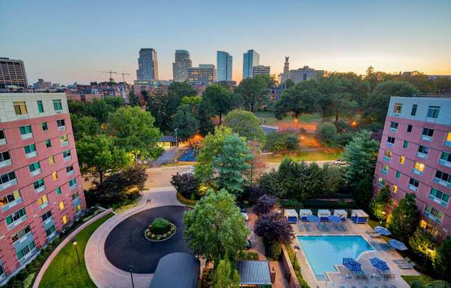 an aerial view of a swimming pool and a city at dusk