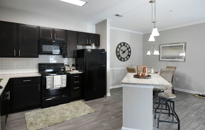 a kitchen with black appliances and a marble counter top