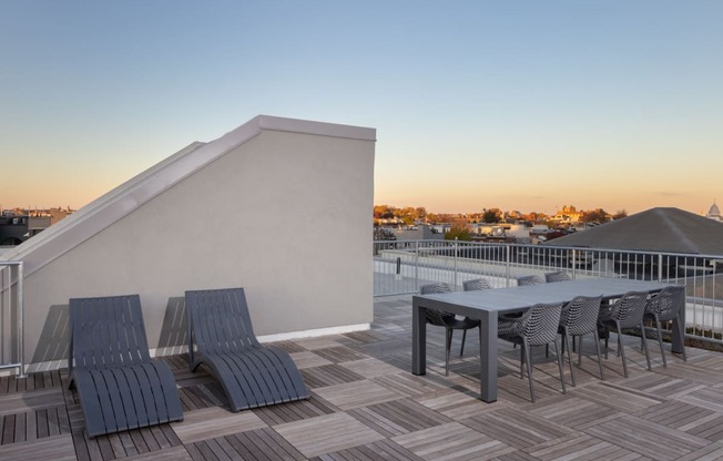 a patio with a table and chairs on top of a roof