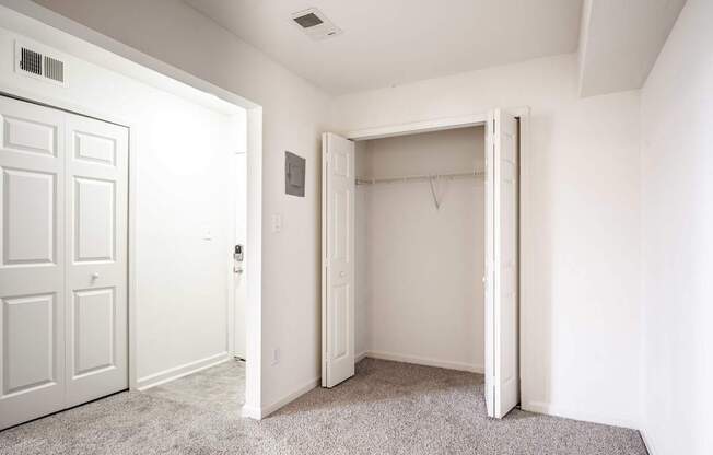 A white door is open to a room with a carpeted floor.