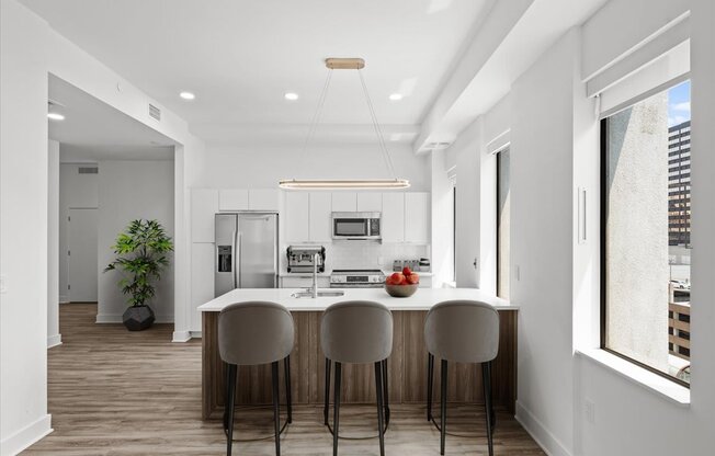 A modern kitchen with a bar stool and a dining table.