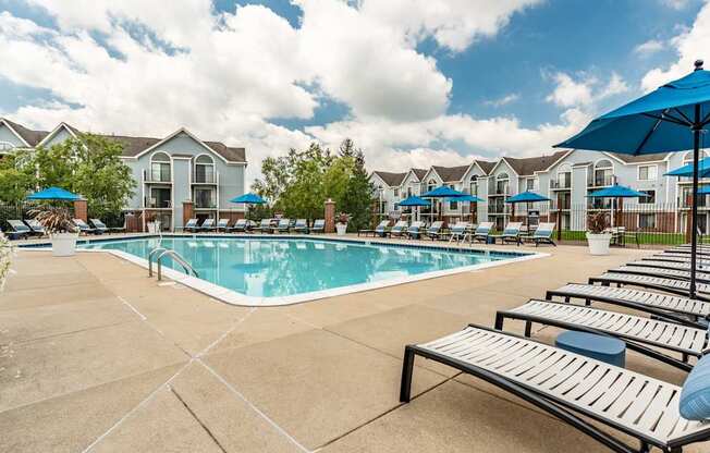 A pool surrounded by sun loungers and umbrellas