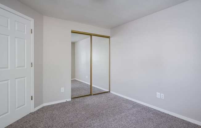 a bedroom with white walls and a carpeted floor