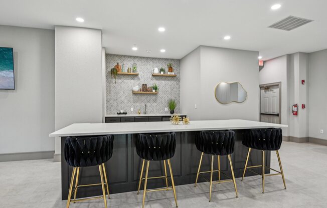 A modern kitchen with a white countertop and black bar stools.