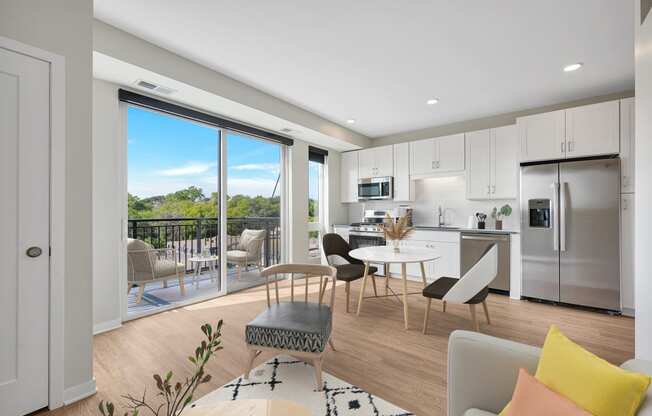 a living room and kitchen with a sliding glass door that leads to a balcony