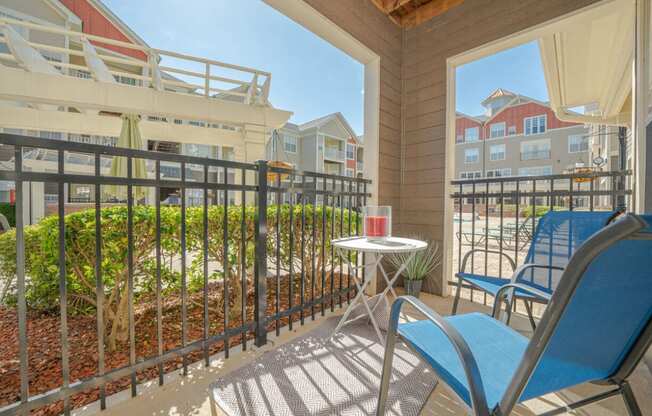 a patio with two chairs and a table on a balcony