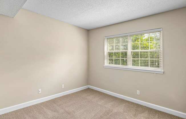 an empty bedroom with a large window