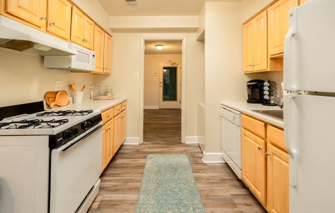 a kitchen with white appliances and wooden cabinets