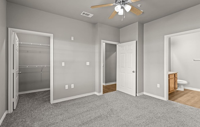 A room with a ceiling fan and a door.