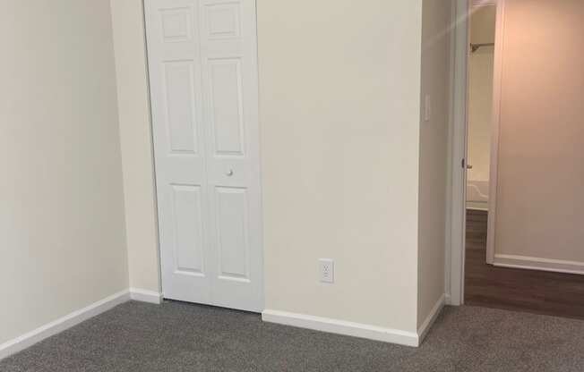 an empty living room with white walls and a door