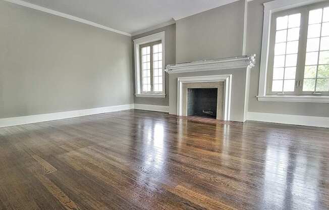 A room with a fireplace and wood flooring.