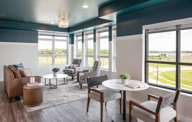 a living room with couches chairs and tables and windows