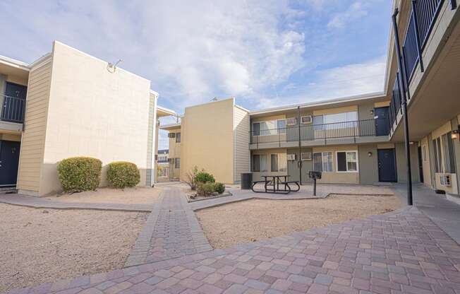 a courtyard between two apartment buildings with a picnic table