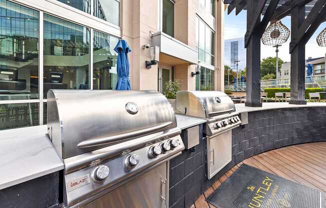 A stainless steel outdoor grill is on a wooden deck.