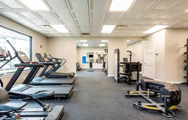 A gym with treadmills, elliptical machines, and other exercise equipment.