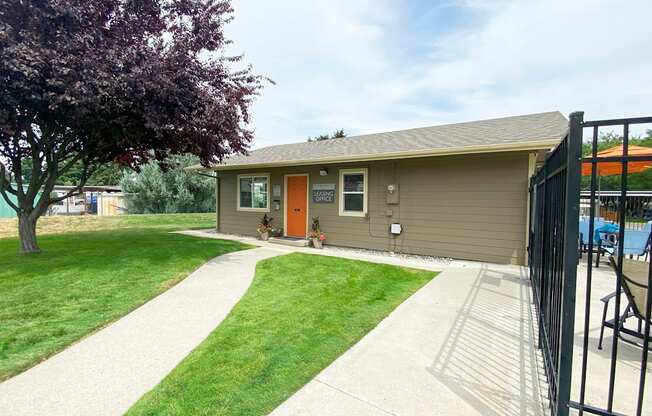 a home with a red door and a large tree in front of it at Park View Apartments, Washington