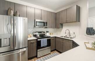 our spacious kitchen is equipped with stainless steel appliances and a white counter top at Lagniappe of Biloxi Apartment Homes, Biloxi