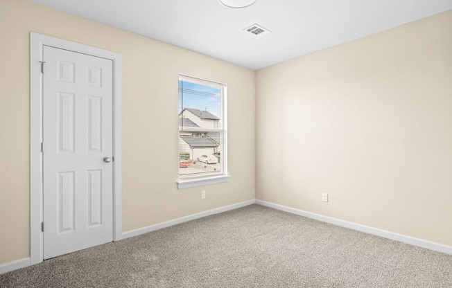an empty room with a white door and a window at Diamond Ridge Townhomes, Oklahoma City, 73114