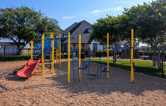 a playground with a swing set in front of a house