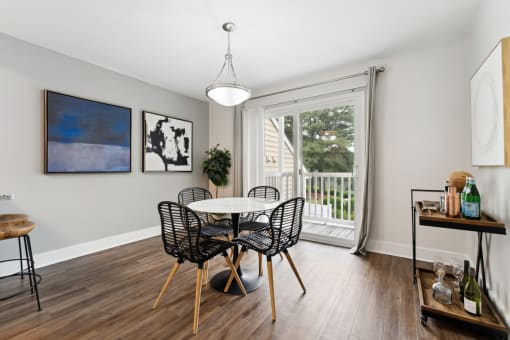 a dining room with a table and chairs and a sliding glass door that leads to a balcony at Linkhorn Bay Apartments, Virginia Beach, VA, 23451