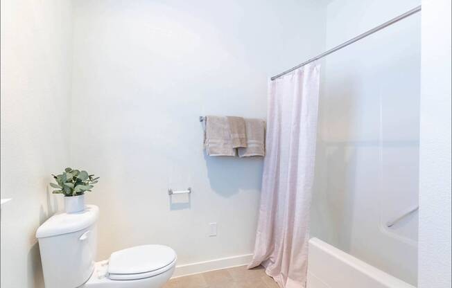 A white toilet sits next to a white sink in a bathroom at Riverplace Apartment Homes, Oregon