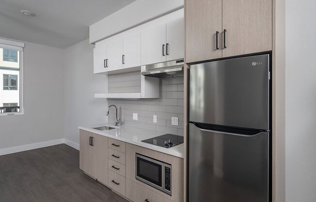 a kitchen with white cabinets and a stainless steel refrigerator