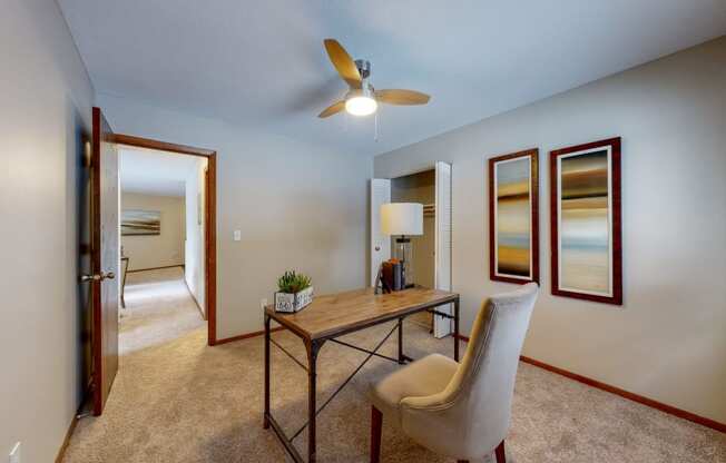 a desk with a chair and a lamp in a room