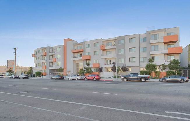 A street view of a residential area with cars parked and driving at Woodley Sara Apartment, California, 91406
