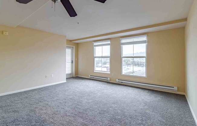 A room with a ceiling fan and carpeted floor.