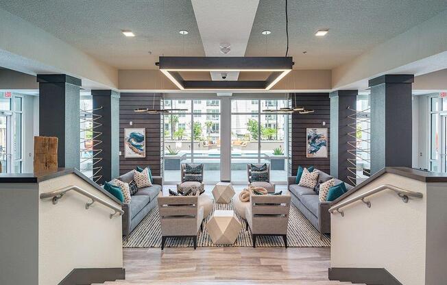a lobby with couches and chairs and a pool in the background