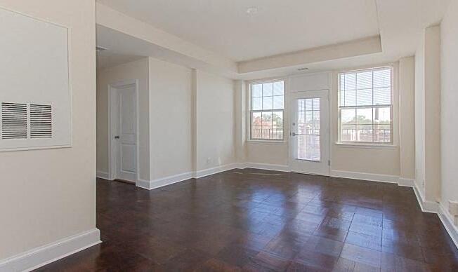 vacant living area with french door leading to balcony and large windows at juniper courts apartments in takoma washington dc