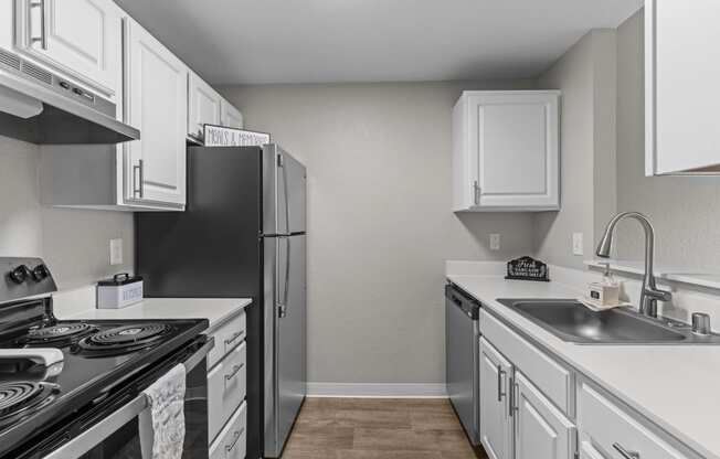 an empty kitchen with white cabinets and stainless steel appliances