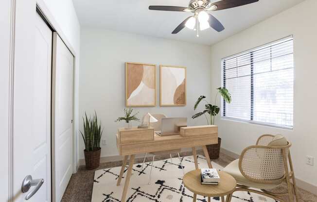 a living room with a ceiling fan and a door to a bedroom