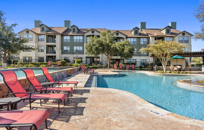 commons pool with chairs and an apartment building at The Fairways at Star Ranch, Hutto