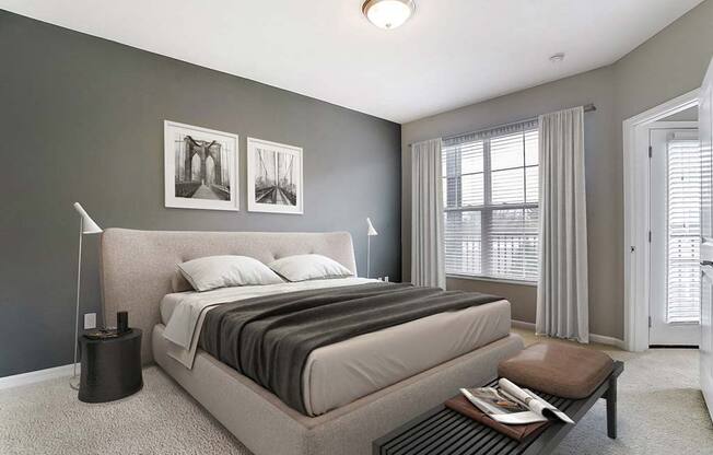 A bedroom with a large bed and a nightstand with a lamp.