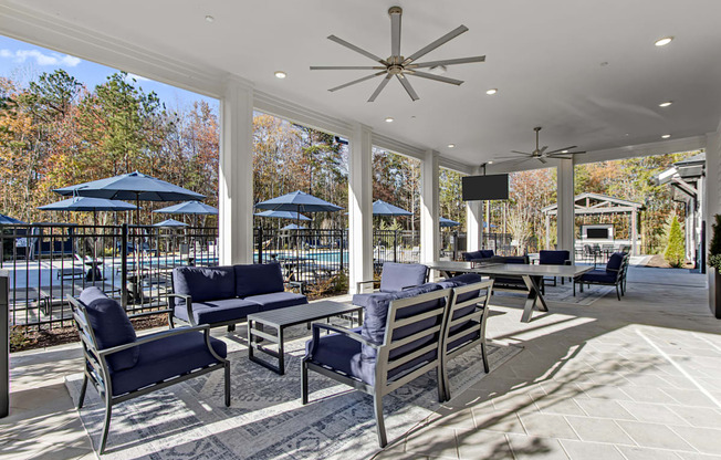 A patio with a table and chairs and a ceiling fan.