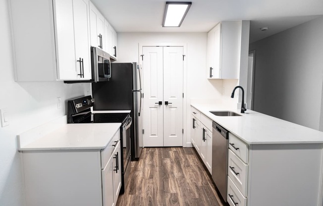 an empty kitchen with white cabinets and a black stove and refrigerator