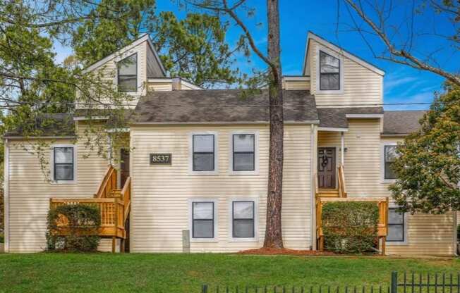 a house with a yard and a tree in front of it