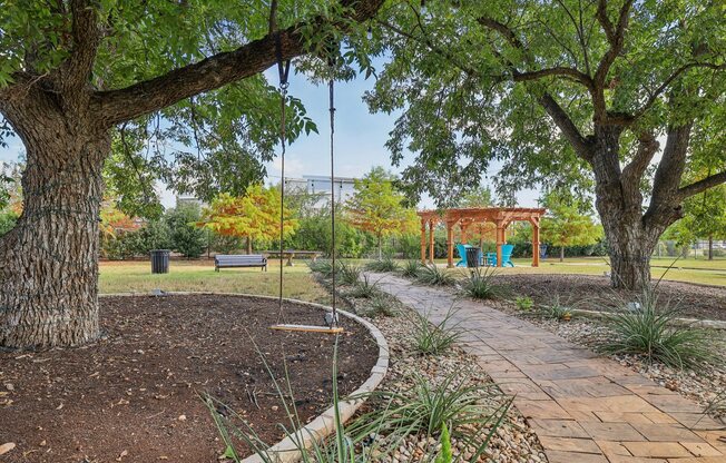 A park with a swing set and a bench.