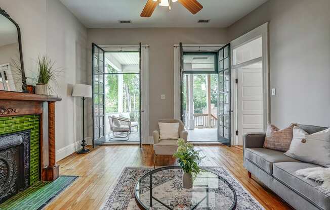 A living room with a fireplace and a glass coffee table.