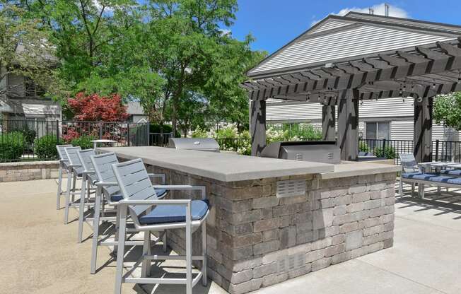 a patio with a bar and chairs and a gazebo