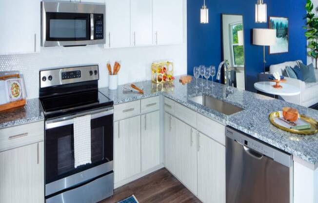 A modern kitchen with a stainless steel oven and microwave.