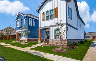 a blue and white house with a sidewalk in front of it