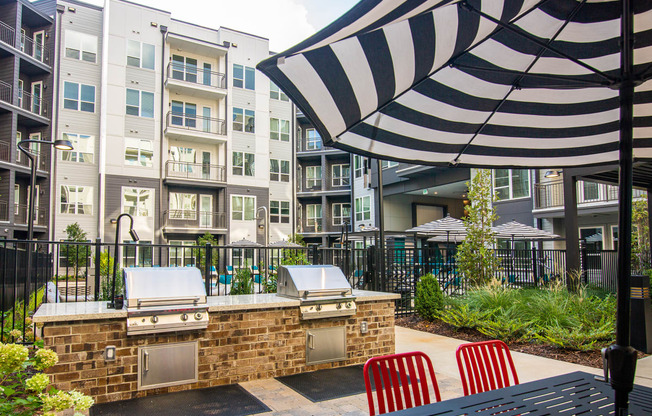 our apartments have a large outdoor patio with a grill and an umbrella