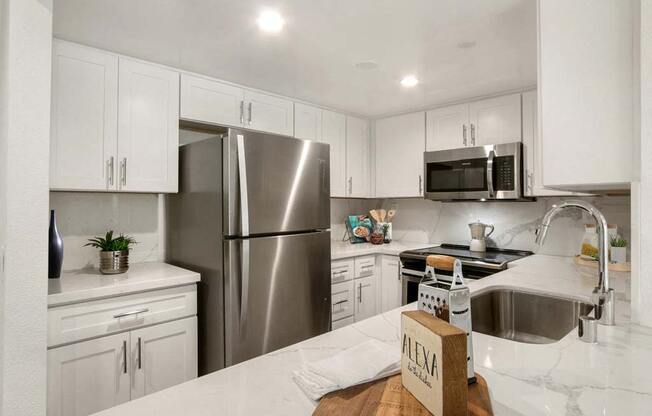 a kitchen with a refrigerator freezer next to a sink  at Masselin Park West, Los Angeles