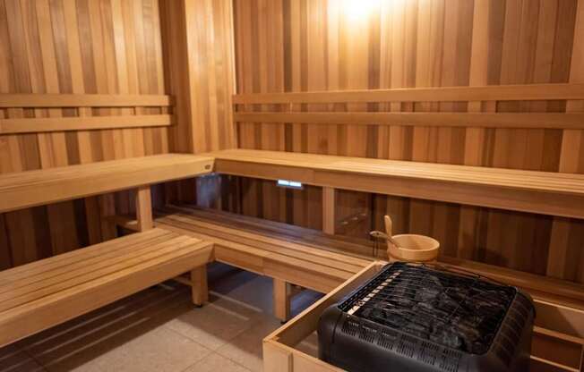 A sauna room with wooden benches and a bench with a black cover on it.